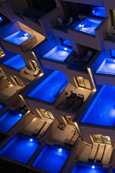 Night view of Ventale Island Breeze Resort's private suites with illuminated blue plunge pools on each balcony