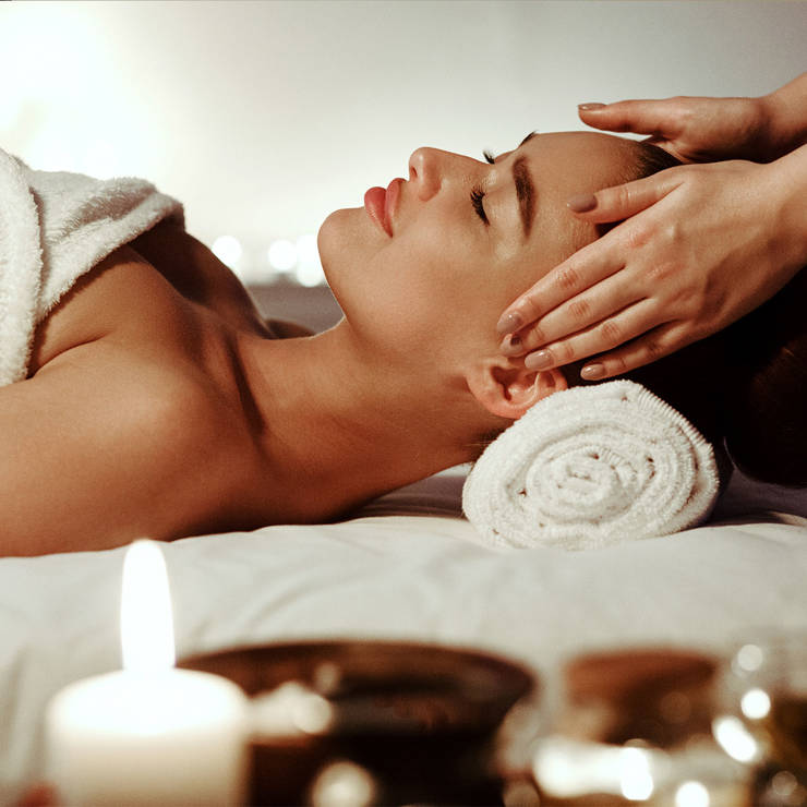 Relaxing spa experience with a person receiving a professional massage on a table with warm candlelight ambiance